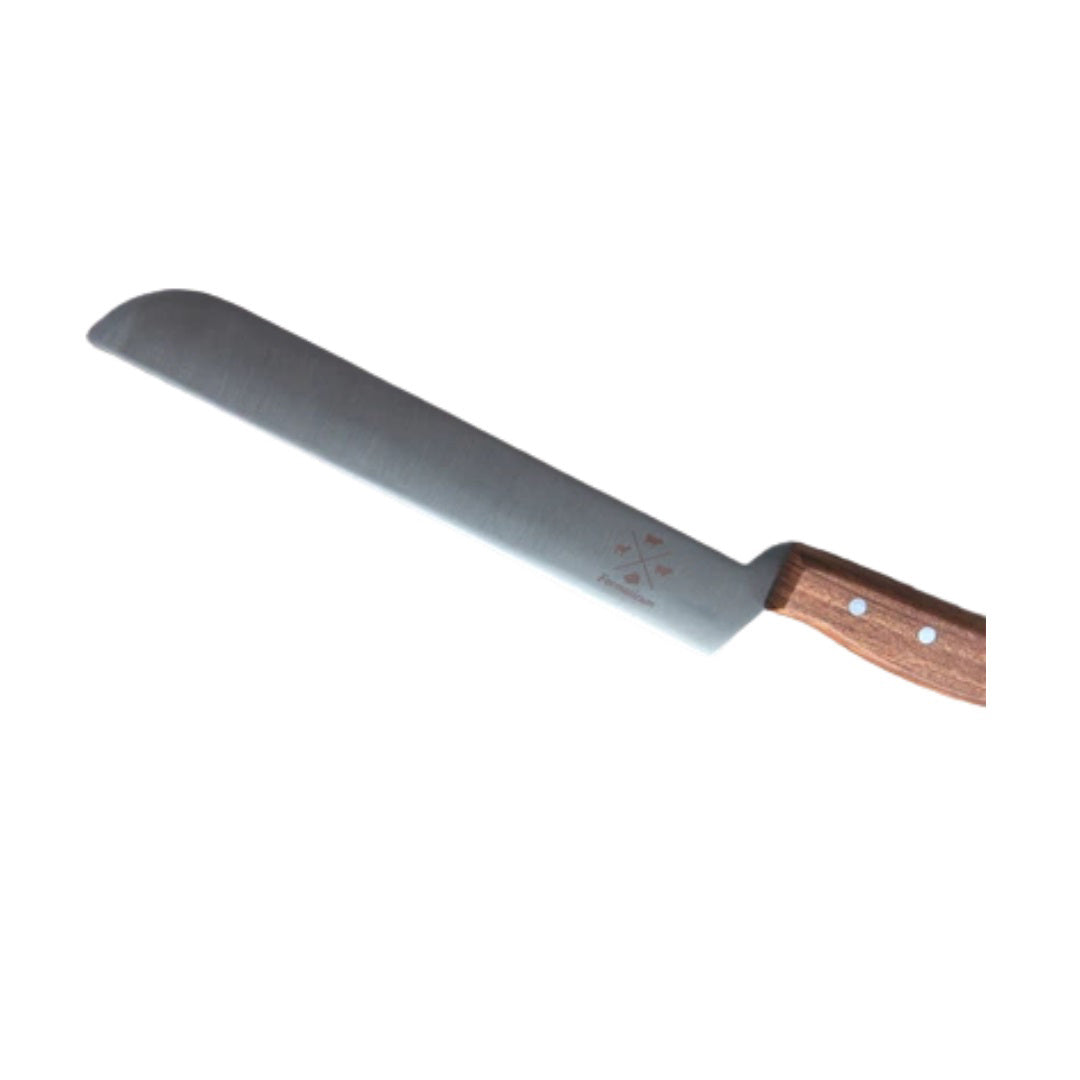 The PRO CHEESE KNIFE by FORMATICUM features a long, straight-edged stainless steel blade that is slightly curved at the tip and showcases a few markings. The knife is fitted with a wooden handle secured by three rivets. Meticulously handmade in Italy, it is displayed against a plain white background.