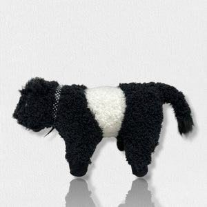A soft plush toy from the Beverly Hills Teddy Bear Co's Fearrington Signature Collection, resembling a black and white Belted Galloway cow, stands against a plain white background. This furry mascot features black fuzzy fur on its head, legs, and tail, with a white fuzzy band around its midsection, characteristic of the Galloway breed.