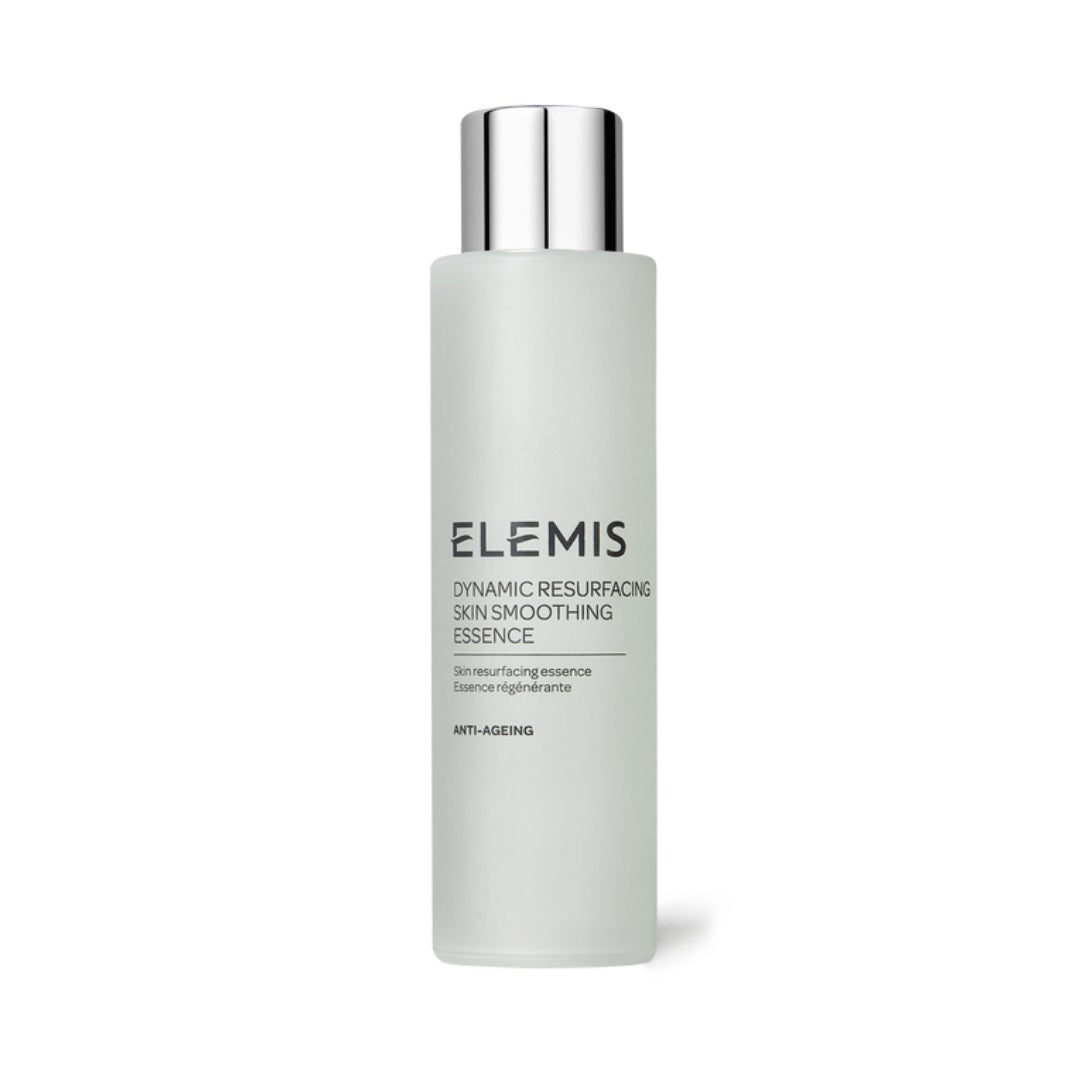 A cylindrical frosted glass bottle from ELEMIS - STEINER, labeled &quot;ELEMIS - DYNAMIC RESURFACING SKIN SMOOTHING ESSENCE,&quot; comes with a silver cap. The description highlights its &quot;Skin resurfacing essence&quot; and &quot;Anti-Ageing&quot; benefits. Featuring Tri-Enzyme Technology, it promises a glass-like complexion.