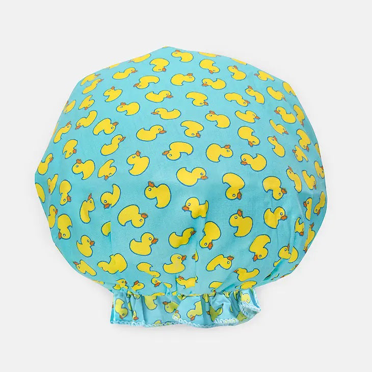 Introducing the BOUFFANT SHOWER CAP from BATH ACCESSORIES COMPANY! This stylish shower cap showcases a vibrant design of colorful macarons in shades of pink, purple, yellow, and brown against a lively green background. It features a waterproof inner layer to keep your hair dry and an elasticated bottom for a secure and comfortable fit.