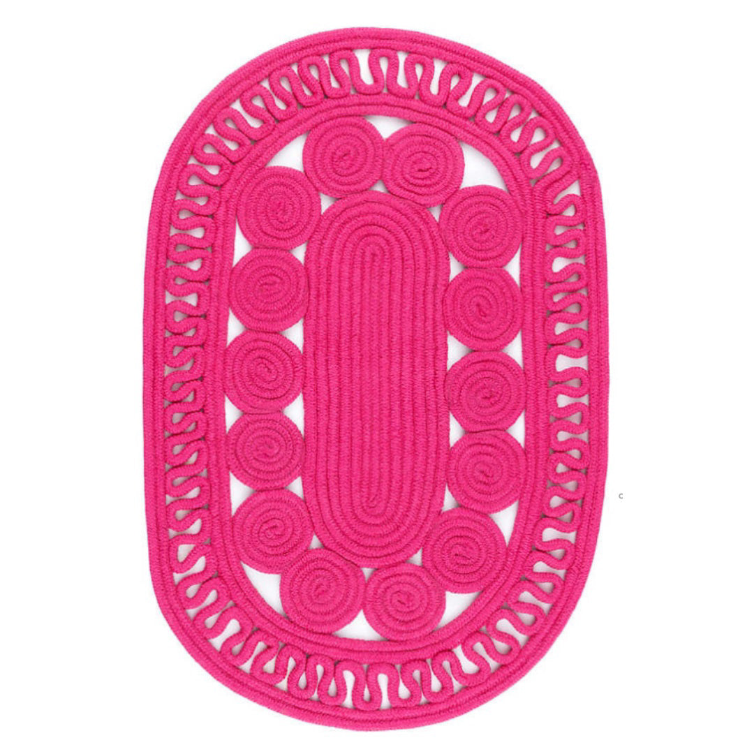 Introducing the REEF IN OUT OVAL 3X5 (FUCHSIA) placemat by ANNIE SELKE, a vibrant pink, oval-shaped lace accent piece. It features a central pattern of spirals surrounded by an outer border with intricate cut-out details. Crafted from performance fiber rope, this stylish design offers both decorative elegance and water resistance.