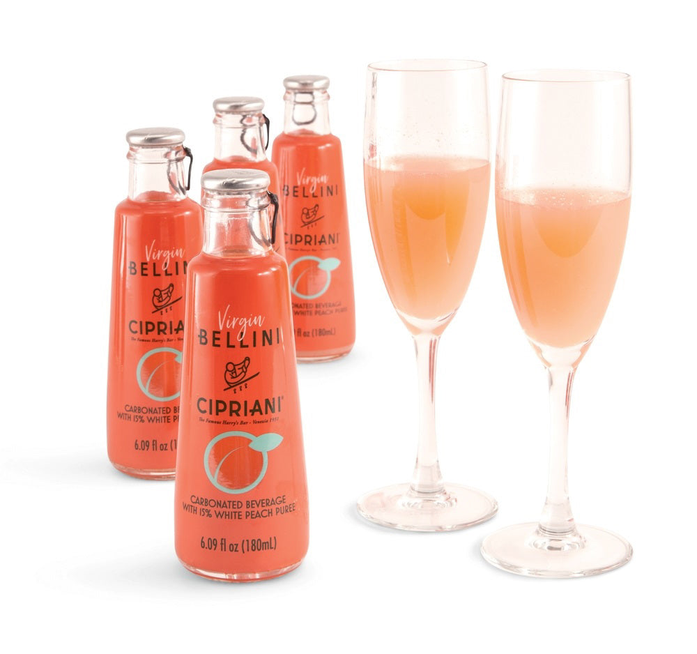 A clear glass bottle of CIPRIANI ALCOHOL-FREE BELLINI by INTERNATIONAL GOURMET FOODS, with pink liquid and a label featuring "Pesca Bianca White Peach" and a peach illustration, highlights its alcohol-free white peach cocktail.
