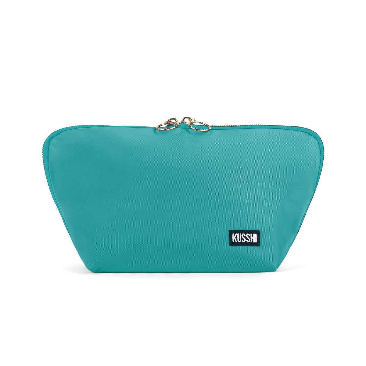The KUSSHI Signature Makeup Bag in Sea Green is a stylish teal zippered bag with a slightly flared shape. It features a top zipper with two gold-tone pull tabs and a small black rectangular patch on the front displaying the brand name &quot;KUSSHI&quot; in white lettering. Inside, you&#39;ll find roomy compartments for all your essentials, and it&#39;s machine washable for easy care.