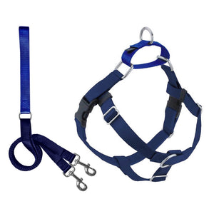 The NO PULL HARNESS LEASH (XS, NAVY) by 2 HOUNDS DESIGN is a blue dog harness with a Swiss velvet-lined chest strap and a blue leash attachment. This freedom no-pull harness features multiple adjustment points, stainless steel hardware, and a top handle. The leash attachment includes a loop handle and two metal clasps for securing to the harness. Both items are made from durable fabric.
