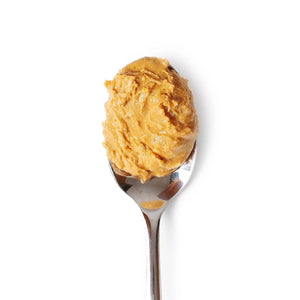 A jar of BIG SPOON ROASTERS - WAG BUTTER BANANA FLAX, a Canine Superfood rich in Omega-3 fatty acids, is shown against a plain white background. The jar features a yellow label with black text and a gold-colored lid, while the light brown butter inside resembles Peanut Butter for Dogs.