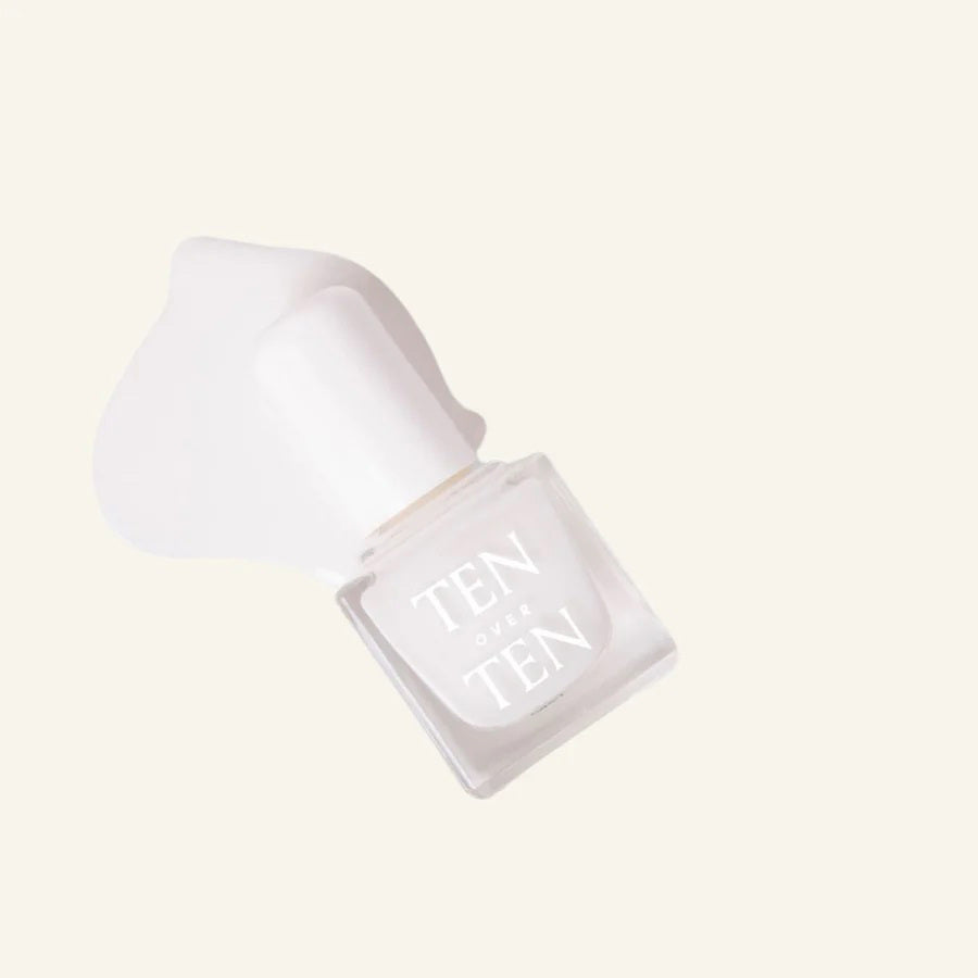 A glass bottle of TENOVERTEN - NAIL POLISH from the brand TEN OVER TEN, featuring a white cap and a dusty pink nail color. The front label displays "TEN OVER TEN" in white uppercase letters. This vegan, eight-free formula ensures both beauty and peace of mind. The background is plain and light-colored.