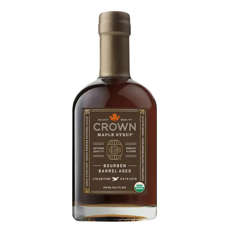 A 375 ml bottle of CROWN MAPLE - BOURBON BARREL AGED MAPLE SYRUP (ORGANIC) features a gold crown logo and dark text on a brown background, finished with a tan cap. This luxury syrup offers artisan and robust flavor notes, is organically certified, and is perfect for elevating pancakes and coffee.