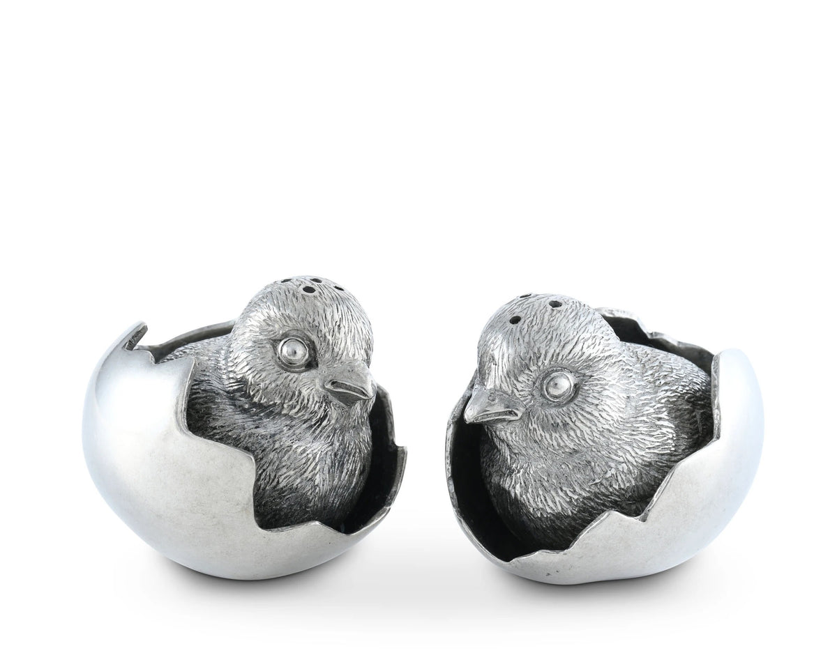 The VAGABOND HOUSE - PEWTER CHICKS IN EGGS SALT AND PEPPER SET features handcrafted shakers shaped like hatching chicks with detailed cracked egg designs, textured feathers, and beady eyes, adding charm to this unique VAGABOND HOUSE tableware.