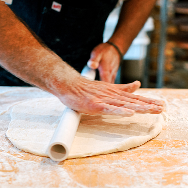rolling pizza dough at roost