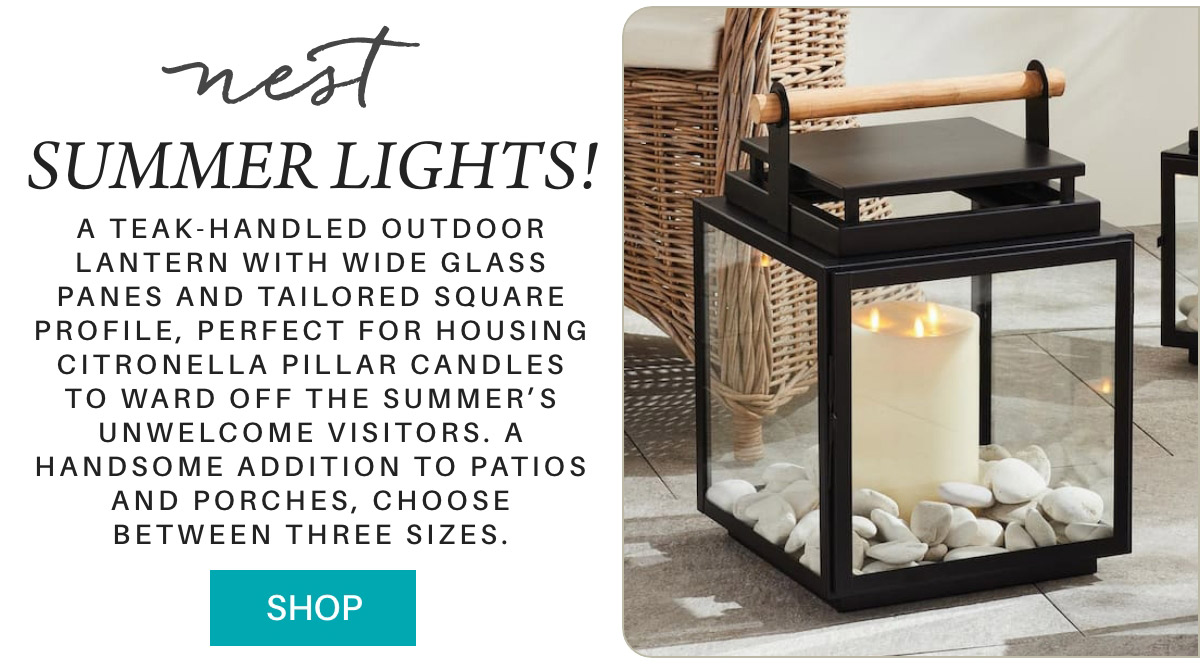 Advertisement for "SUMMER LIGHTS!" from Nest, showcasing a teak-handled outdoor lantern with wide glass panes. The lantern features a citronella pillar candle inside and decorative white pebbles at the base. Text describes product details and purchase options. Fearrington Village