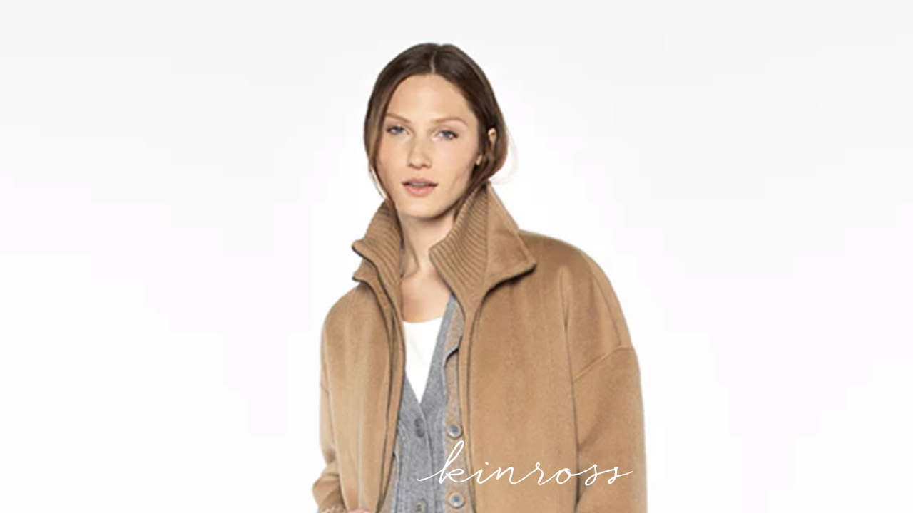 A person with a neutral expression is wearing a camel-colored coat over a gray cardigan and white top. They have straight hair pulled back. The background is white, and the word "kinross" is written at the bottom in cursive. Fearrington Village