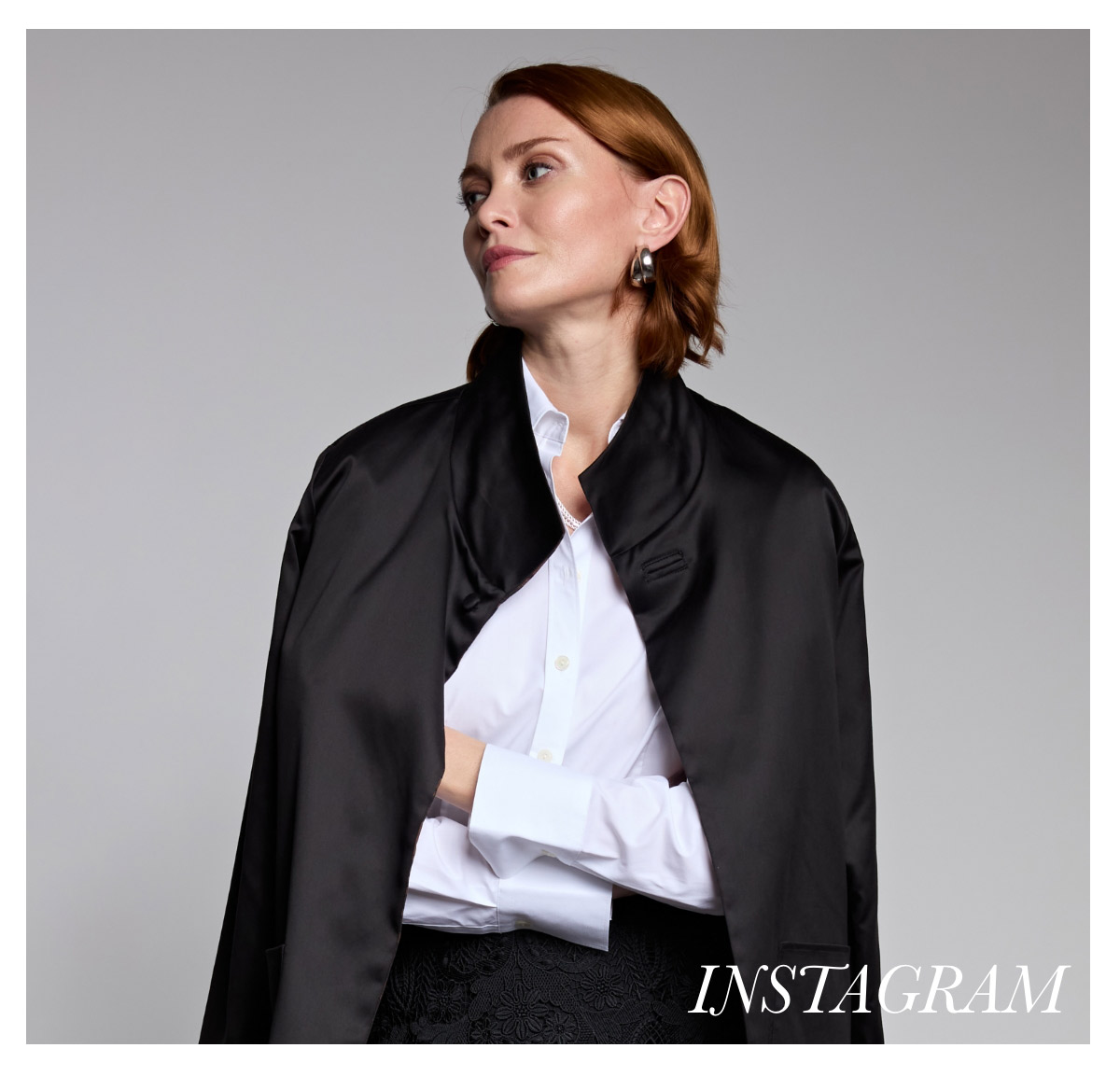 A person with red hair is looking off to the side, wearing a black satin shawl over a white shirt. The background is plain gray, and the word "Instagram" is written in the bottom right corner. Fearrington Village