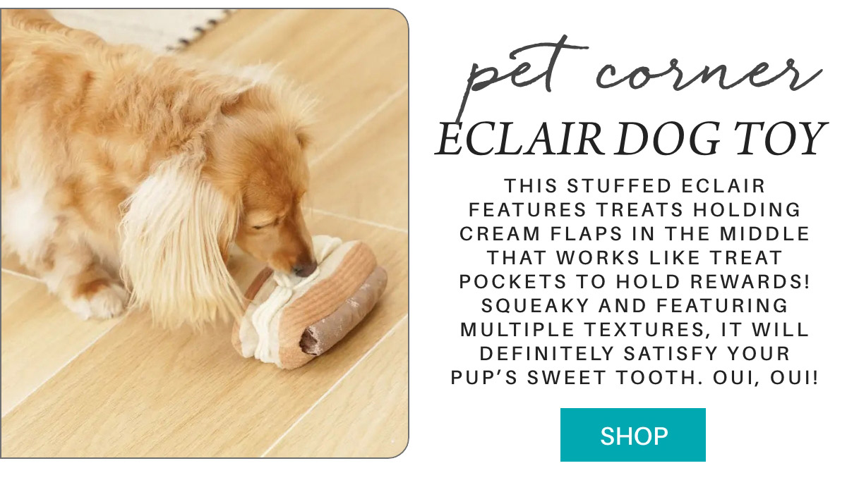 A dog is on a wooden floor playing with a stuffed eclair toy, designed to hold treats and offer various textures. The ad highlights its squeaky feature and suggests it will satisfy a dog's sweet tooth. A "Shop" button is at the bottom. Fearrington Village