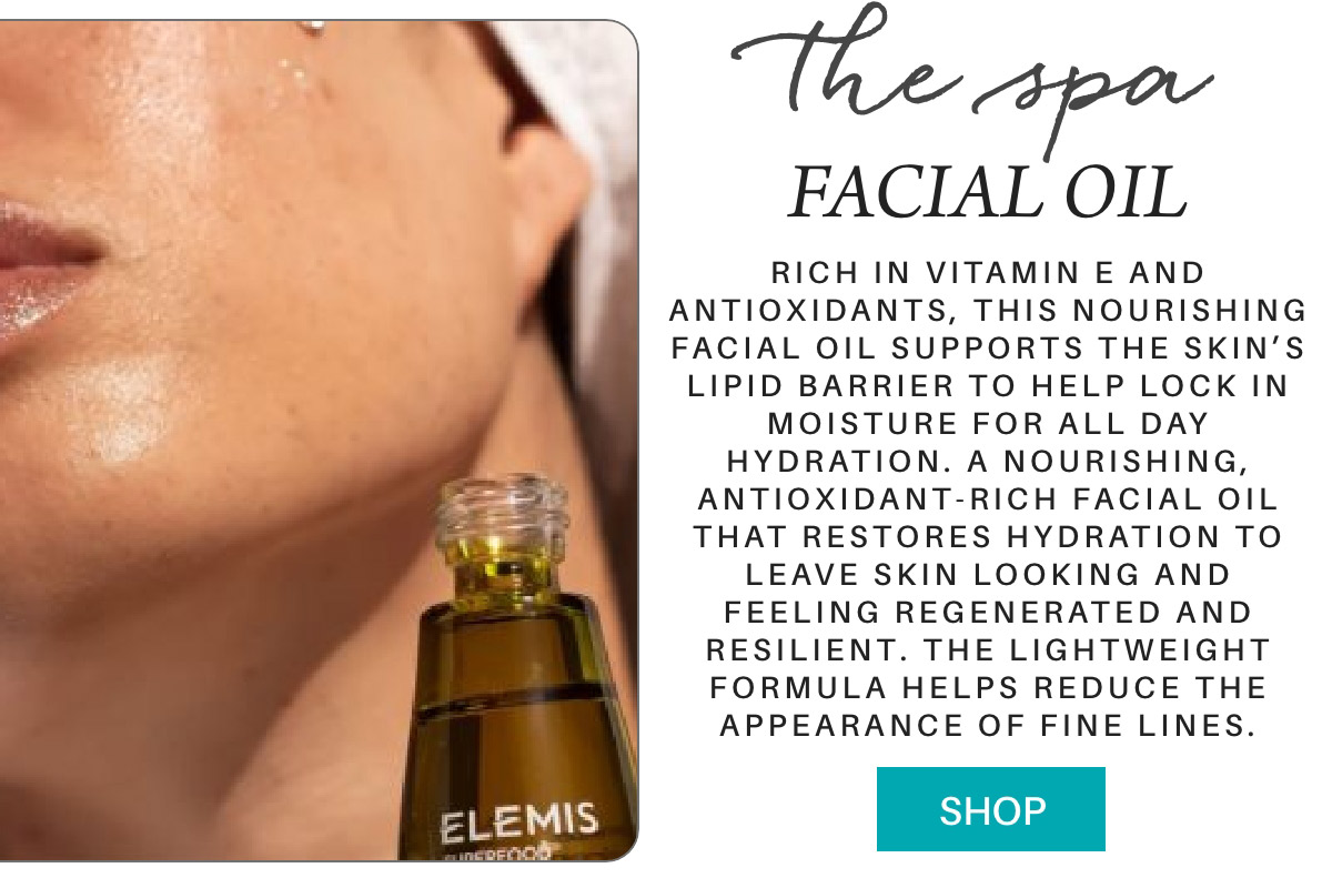 Close-up of a person's face with a drop of facial oil on their skin. A bottle labeled "Elemis" appears in the foreground. Text describes the oil as rich in vitamins and antioxidants, promoting hydration and regeneration. A "Shop" button is displayed. Fearrington Village