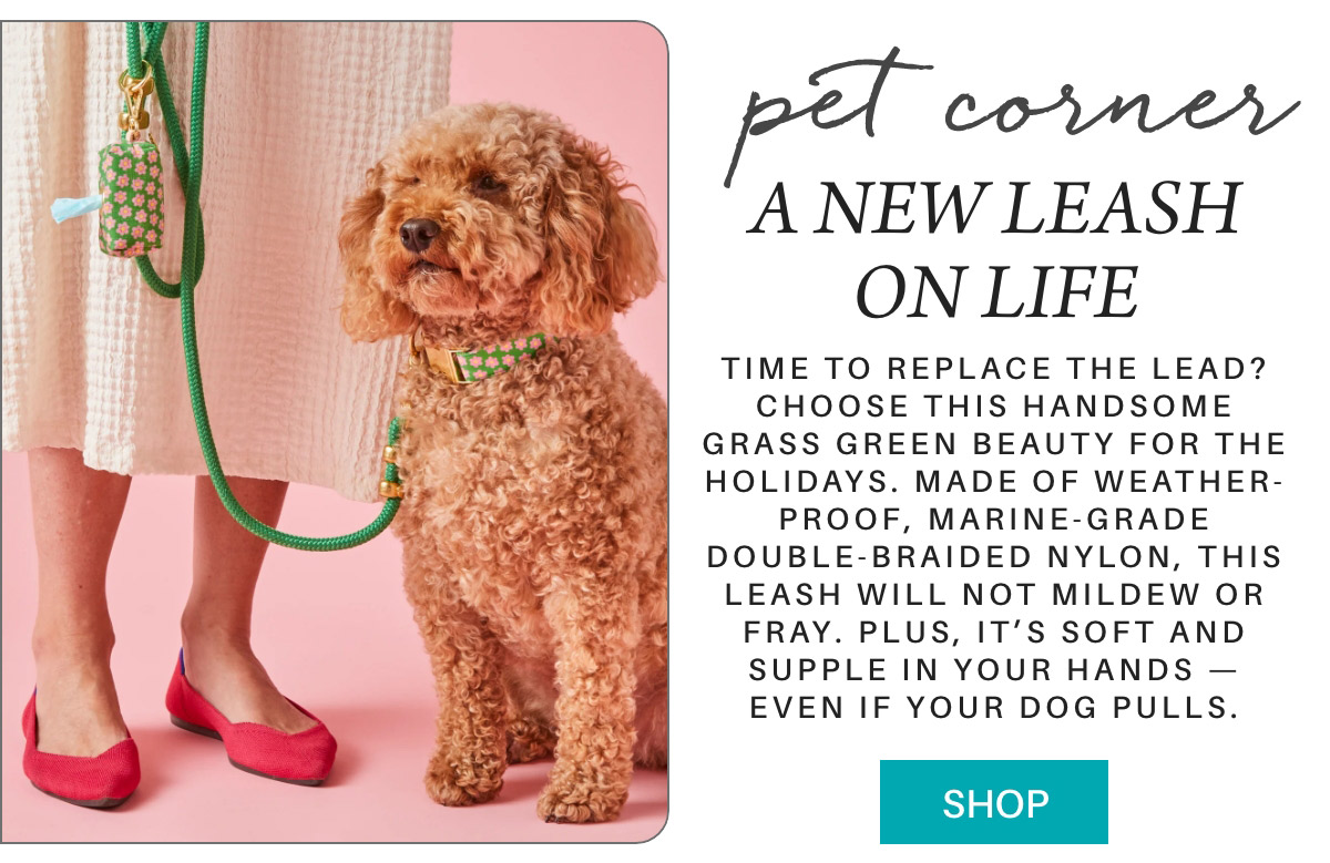 A curly-haired dog on a pink background stands beside a person wearing a cream skirt and red shoes. The dog has a green leash and collar. Text promotes a new weatherproof, mildew-resistant, double-braided nylon leash available for purchase. Fearrington Village