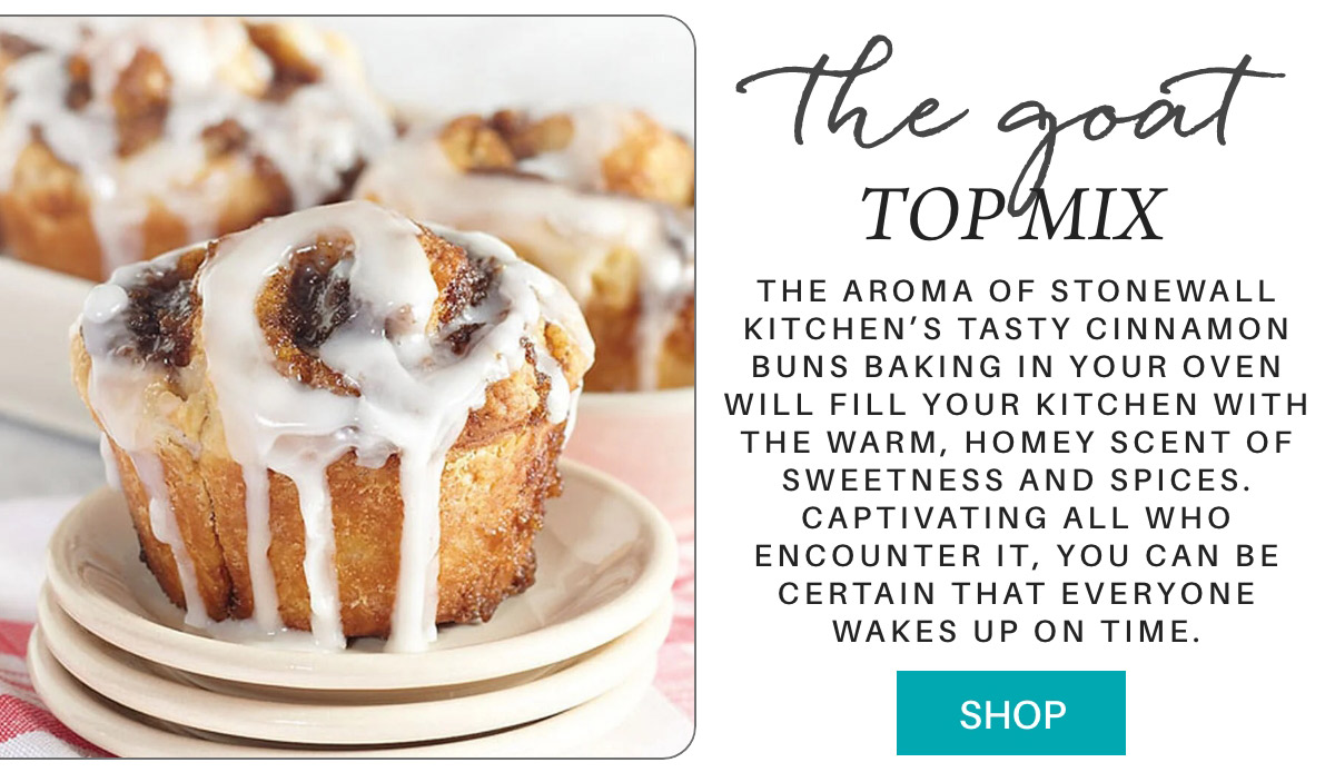 A close-up of a cinnamon bun drizzled with white icing on a white plate. Text describes the aroma and sweetness of Stonewall Kitchen's cinnamon buns. To the right, a "shop" button is displayed. Fearrington Village