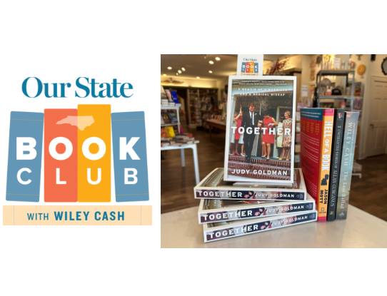 A display of books from the "Our State Book Club with Wiley Cash" featuring "Together" by Judy Goldman on top. The stack is inside a bookstore with wooden shelves and various books visible in the background. The book club logo is on the left. Fearrington Village