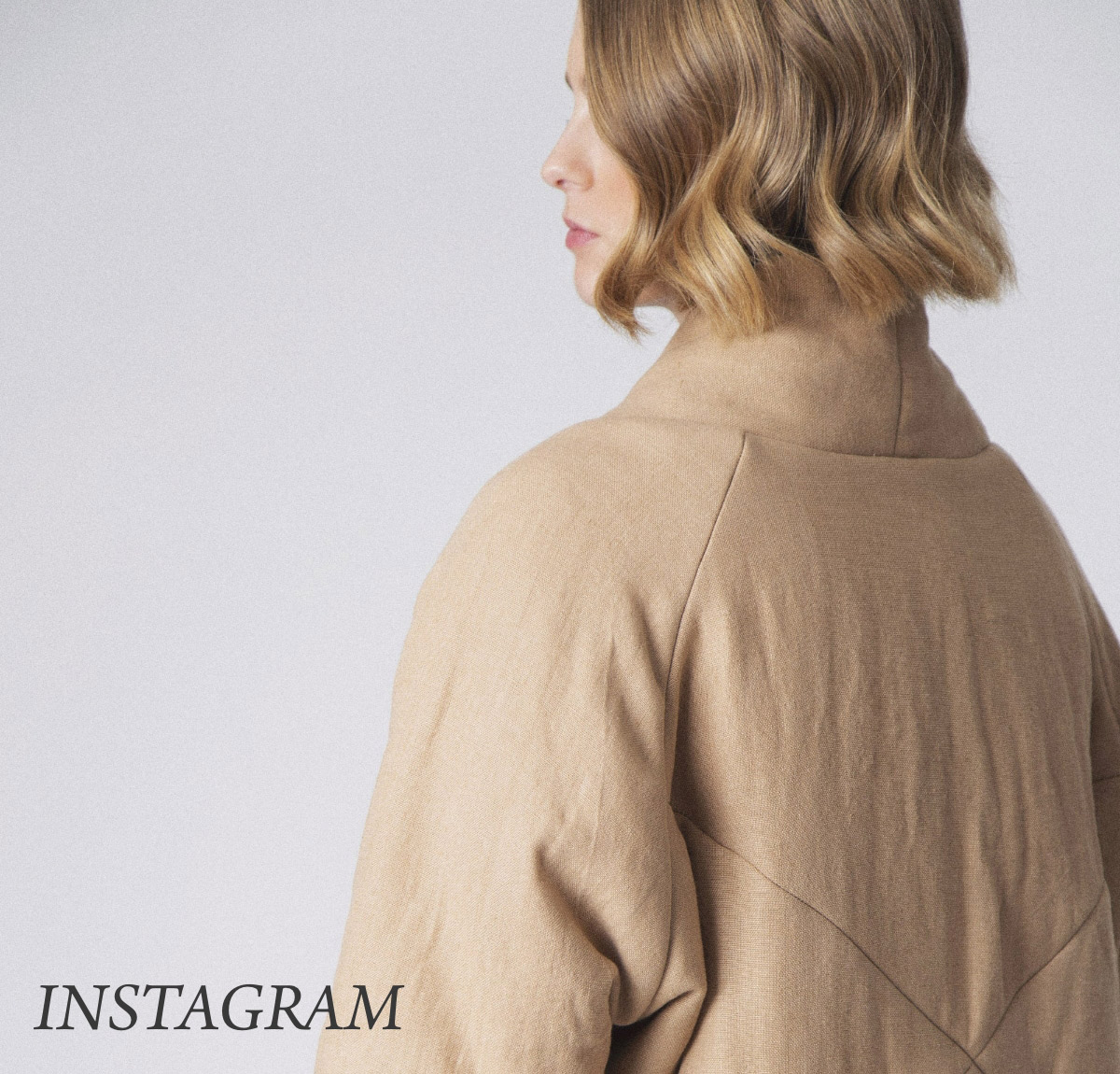 Person with wavy, shoulder-length hair, viewed from behind, wearing a beige coat. The word "INSTAGRAM" is at the bottom left. The background is a plain light gray. Fearrington Village