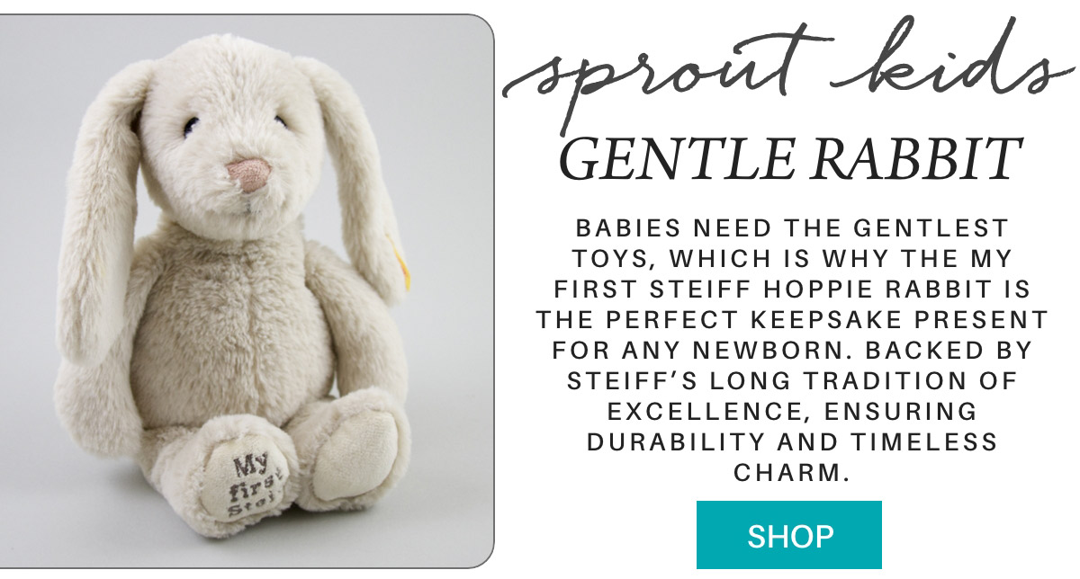 A plush rabbit toy with floppy ears sits against a gray background. Text reads, "Sprout Kids Gentle Rabbit" and describes it as a soft, durable keepsake for newborns by Steiff. A button below reads "Shop. Fearrington Village