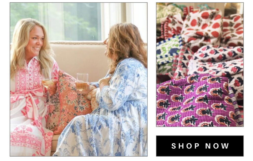 Two women in patterned dresses sit on a sofa drinking tea and smiling. The inset shows a pile of colorful, patterned fabric. A "Shop Now" button is at the bottom right. Fearrington Village