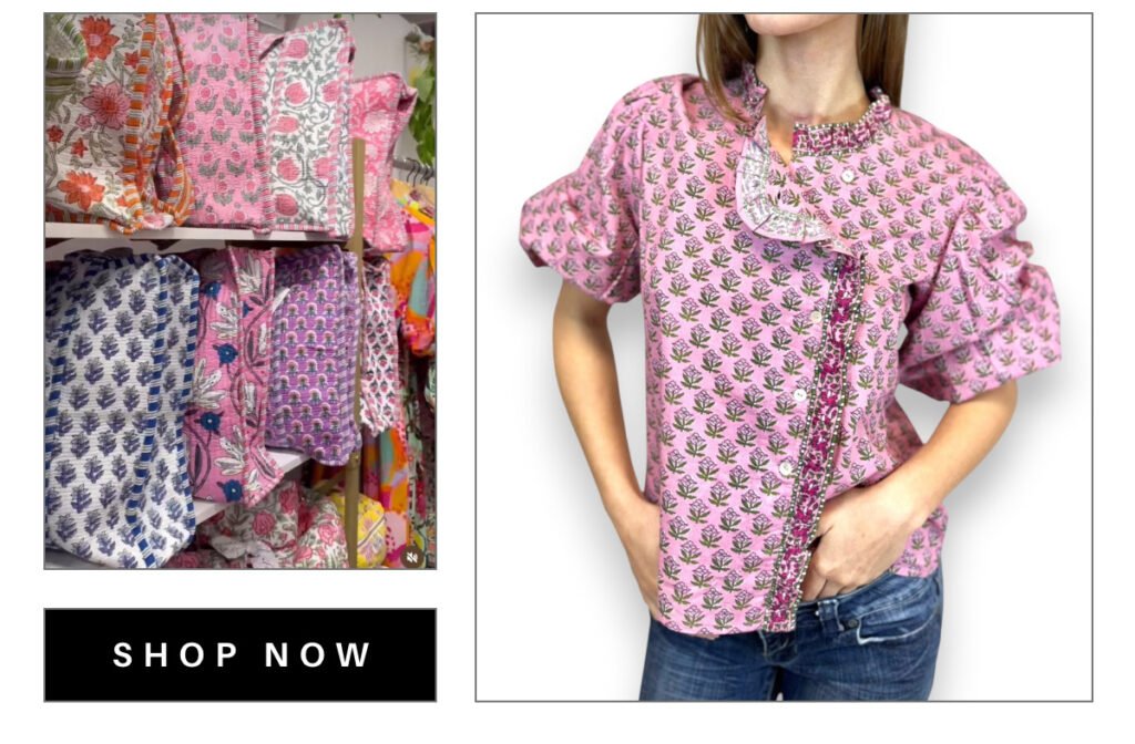 On the left, a shelf with colorful patterned fabrics. On the right, a person wearing a pink floral-patterned blouse with ruffled sleeves and neckline, paired with blue jeans. A "Shop Now" button is at the bottom left. Fearrington Village