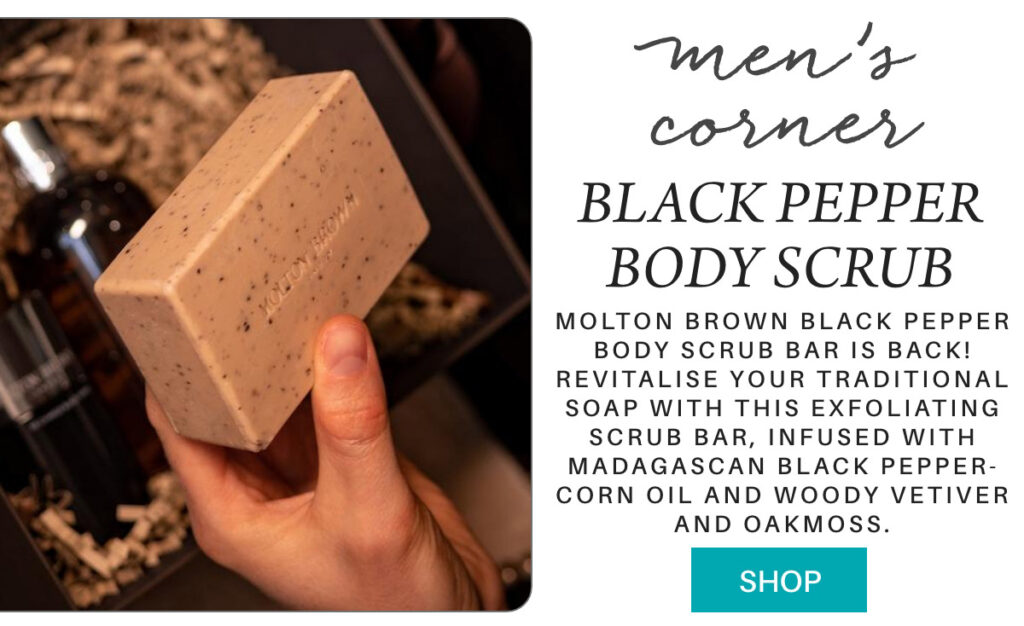 A person holds a Molton Brown Black Pepper Body Scrub Bar against a background of a gift box containing the soap and other products. Text reads: "Men's corner. Black Pepper Body Scrub. Shop. "Molton Brown Black Pepper Body Scrub Bar is back! Revitalise your traditional soap with this exfoliating scrub bar, infused with Madagascan black pepper-corn oil and woody vetiver and oakmoss." Fearrington Village