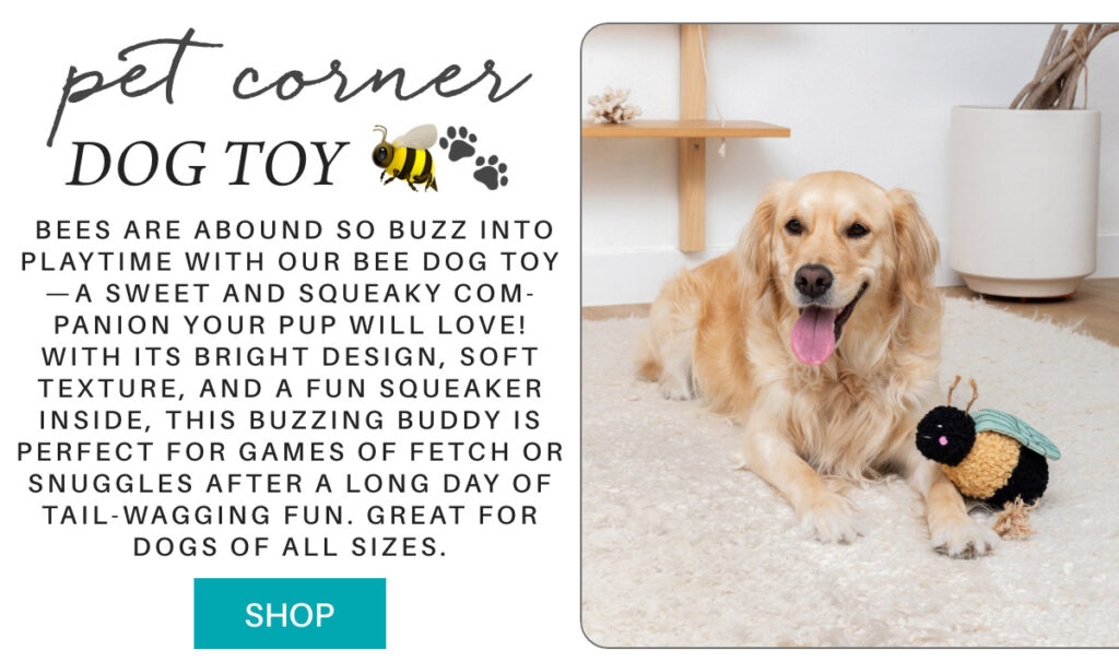 A golden retriever lies on a light-colored rug beside a bee-themed dog toy. The image includes text describing the toy as a squeaky, vibrant playmate suitable for dogs of all sizes. A turquoise "SHOP" button is visible at the bottom left. " Bees are abound so Buzz into playtime with our Bee Dog Toy—a sweet and squeaky com-panion your pup will love! With its bright design, soft texture, and a fun squeaker inside, this buzzing buddy is perfect for games of fetch or snuggles after a long day of tail-wagging fun. Great for dogs of all sizes." Fearrington Village