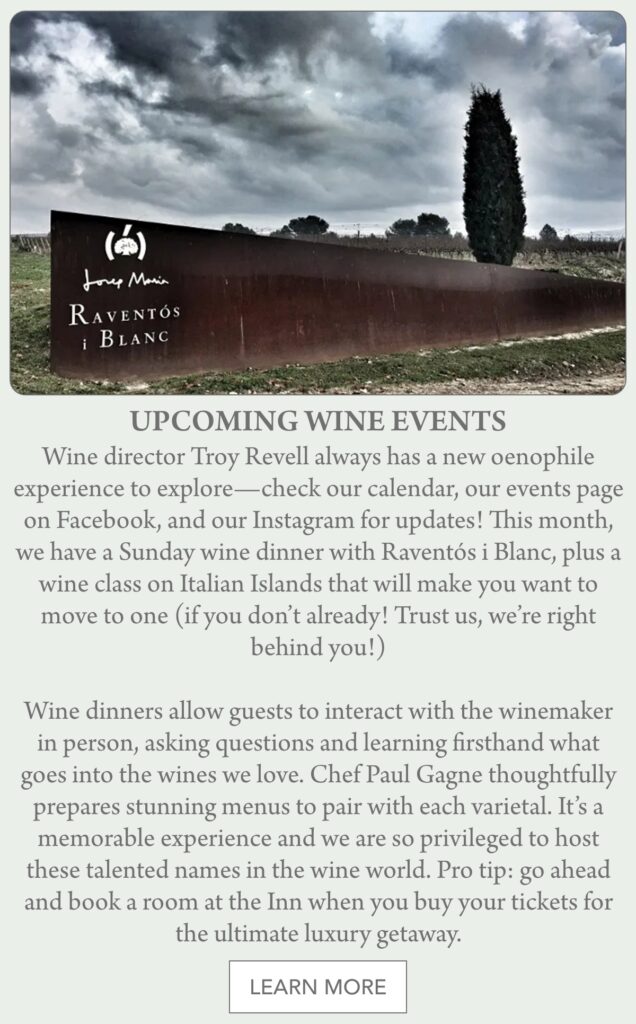 A wooden Raventós i Blanc winery sign sits in a green field with a large barn and trees in the background. Text below announces upcoming wine events and a button says "Learn More." "Wine director Troy Revell always has a new oenophile experience to explore—check our calendar, our events page on Facebook, and our Instagram for updates! This month, we have a Sunday wine dinner with Raventós i Blanc, plus a wine class on Italian Islands that will make you want to move to one (if you don’t already! Trust us, we’re right behind you!) Wine dinners allow guests to interact with the winemaker in person, asking questions and learning firsthand what goes into the wines we love. Chef Paul Gagne thoughtfully prepares stunning menus to pair with each varietal. It’s a memorable experience and we are so privileged to host these talented names in the wine world. Pro tip: go ahead and book a room at the Inn when you buy your tickets for the ultimate luxury getaway." Fearrington Village