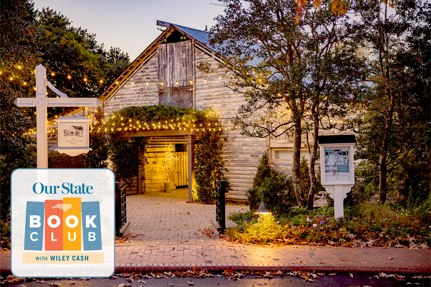 Our State Book Club Event with Wiley Cash, Clyde Edgerton, Bland Simpson, and Elizabeth Hudson 51 A rustic wooden building with warm string lights glowing around the entrance, surrounded by trees and autumn leaves. In the corner, a "Our State Book Club with Wiley Cash" logo appears. Fearrington Village