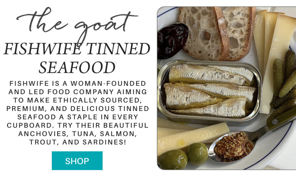 An open tin of sardines sits on a plate with cheese, bread, olives, pickles, whole-grain mustard, and a date. Text promotes Fishwife Tinned Seafood as a woman-founded, ethical seafood company. A "SHOP" button is included. "Fishwife is a woman-founded and led food company aiming to make ethically sourced, premium, and delicious tinned seafood a staple in every cupboard. try their beautiful anchovies, tuna, salmon, trout, and sardines!" Fearrington Village