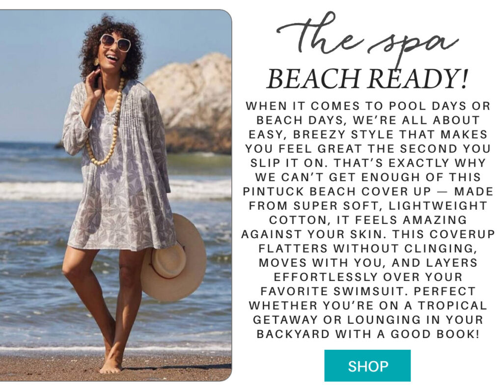 A smiling woman stands on a sandy beach next to rocks, wearing sunglasses, a light pin-tuck coverup dress, and holding a wide-brim hat. The text promotes the dress as a breezy, beach-ready essential. "When it comes to pool days or beach days, we’re all about easy, breezy style that makes you feel great the second you slip it on. That’s exactly why we can’t get enough of this Pintuck Beach Cover Up — made from super soft, lightweight Cotton, it feels amazing against your skin. This coverup flatters without clinging, moves with you, and layers effortlessly over your favorite swimsuit. perfect whether you’re on a tropical getaway or lounging in your backyard with a good book!" Fearrington Village