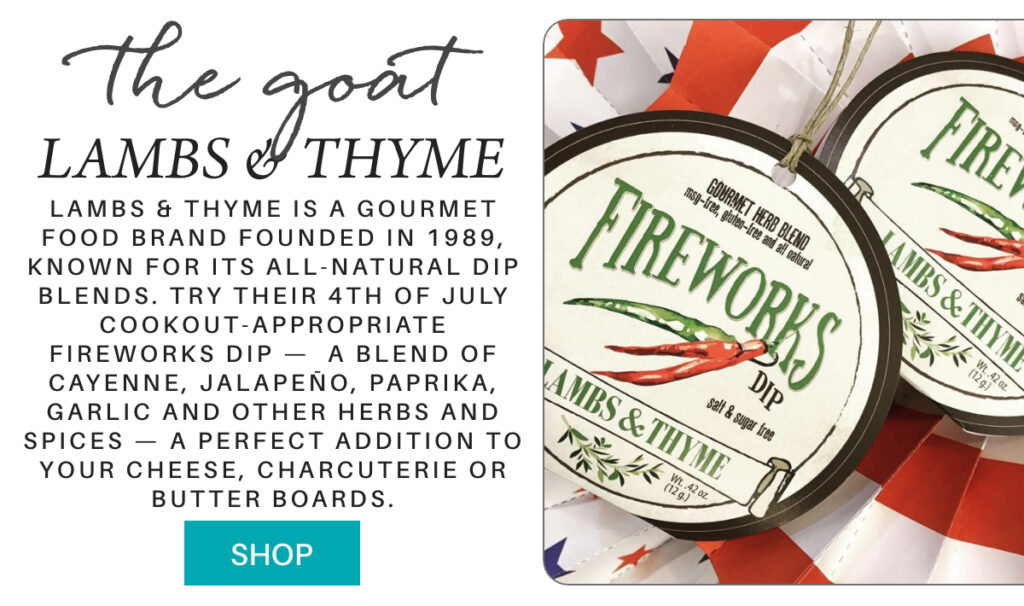A tag reading "Fireworks Dip: Lambs & Thyme" hangs on a display with red, white, and blue star-patterned paper. Text beside it describes Lambs & Thyme's spicy dip blends, ideal for cheese and charcuterie boards. "Lambs & Thyme is a gourmet food brand founded in 1989, known for its all-natural dip blends. try their 4th of july cookout-appropriate fireworks dip — a blend of Cayenne, Jalapeño, paprika, garlic and other herbs and spices — a perfect addition to your cheese, charcuterie or butter boards." Fearrington Village