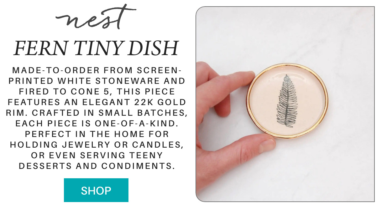 A hand holds a small round dish with a black fern illustration and a gold rim. Text beside it describes the dish’s 22k gold detailing, uniqueness, and uses for jewelry, candles, or small foods. A “Shop” button is below the text. "Made-to-order from screen-printed white stoneware and fired to cone 5, this piece features an elegant 22k gold rim. crafted in small batches, each piece is one-of-a-kind. perfect in the home for holding jewelry or candles, or even serving teeny desserts and condiments." Fearrington Village