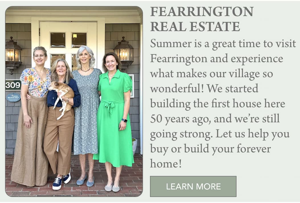 July in Fearrington Village 15 Four smiling women stand together on a brick porch in front of a house with a small dog. A sign titled "FEARRINGTON REAL ESTATE" invites people to buy or build a home. A green "LEARN MORE" button is below the text. Fearrington Village