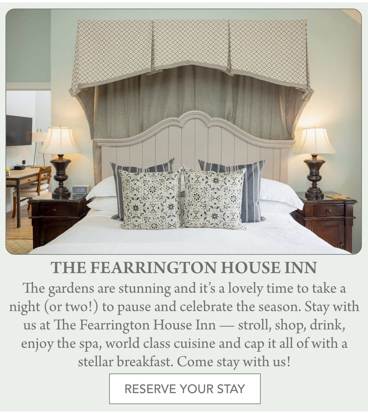 A cozy bedroom at The Fearrington House Inn with a large bed, patterned pillows, elegant lamps on wooden nightstands, and a fabric canopy. Text invites guests to stay and enjoy the amenities. Fearrington Village