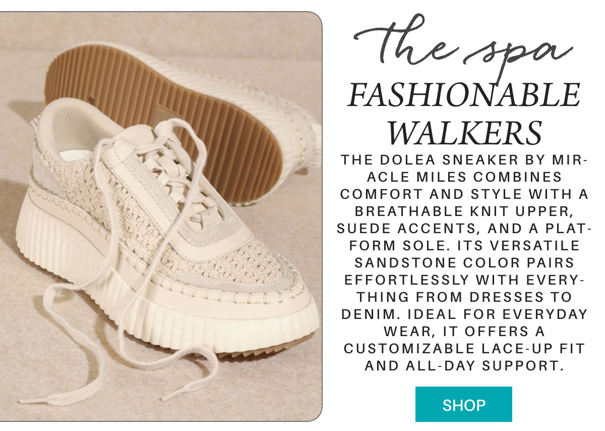 A pair of beige knit sneakers with thick, ribbed platform soles sits on a tan surface. One shoe is upright and laced, while the other lies on its side, showing its textured sole. "The Dolea sneaker by Mir-acle Miles combines comfort and style with a breathable knit upper, suede accents, and a plat-form sole. Its versatile sandstone color pairs effortlessly with every-thing from dresses to denim. Ideal for everyday wear, it offers a customizable lace-up fit and all-day support." Fearrington Village