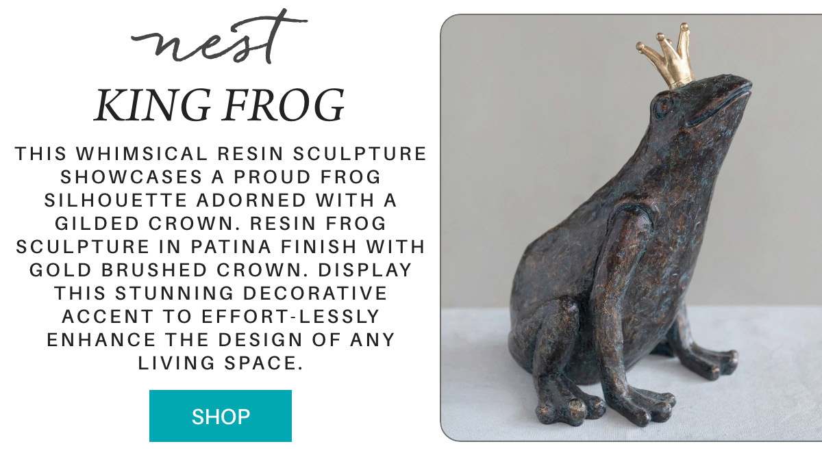 A whimsical resin frog sculpture with a gold crown sits on a light surface; the text describes its patina finish and decorative appeal, with a turquoise "Shop" button below. "This whimsical resin sculpture showcases a proud frog silhouette adorned with a gilded crown. Resin frog sculpture in patina finish with gold brushed crown. Display this stunning decorative accent to effort-lessly enhance the design of any living space." Fearrington Village