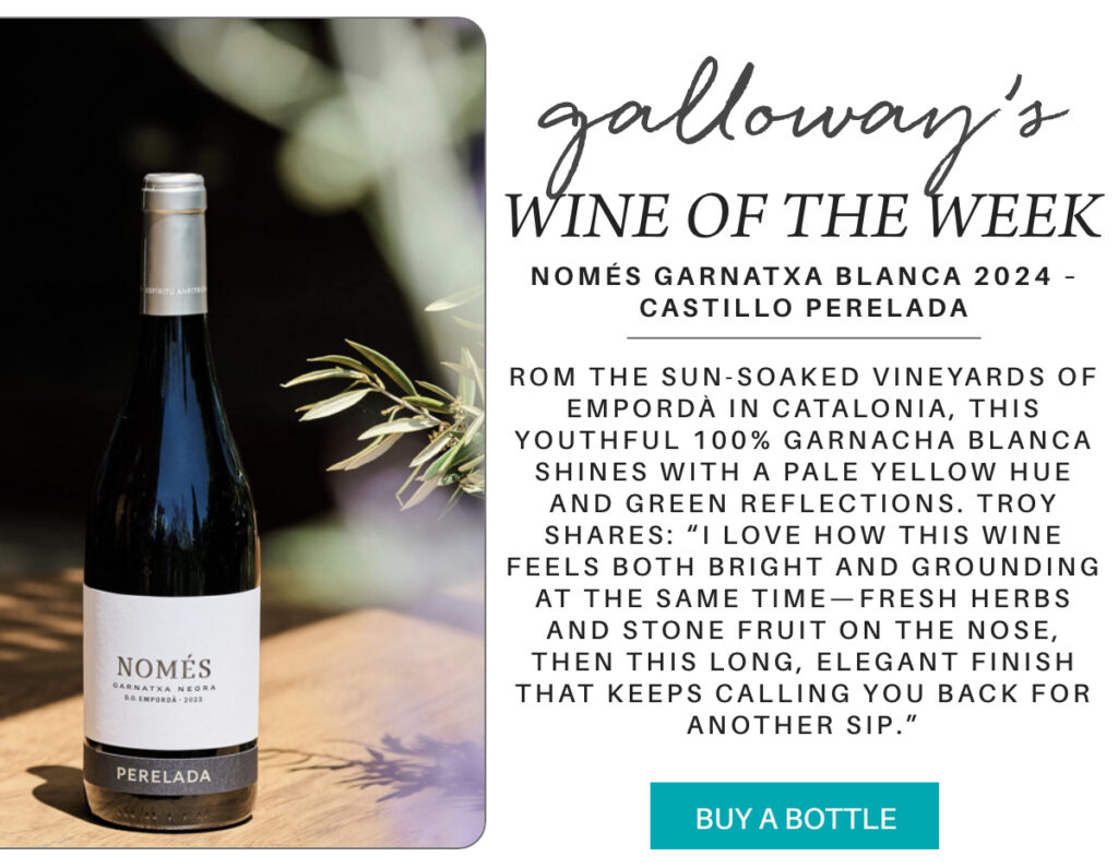 A bottle of Només Garnatxa Blanca wine stands on a black table outdoors beside an olive branch, with a blurred background. Text describes it as Galloway’s Wine of the Week from Castillo Perelada. "Només Garnatxa Blanca 2024 – Castillo Perelada - rom the sun-soaked vineyards of Empordà in Catalonia, this youthful 100% Garnacha Blanca shines with a pale yellow hue and green reflections. Troy shares: “I love how this wine feels both bright and grounding at the same time—fresh herbs and stone fruit on the nose, then this long, elegant finish that keeps calling you back for another sip." Fearrington Village