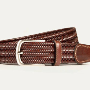 A brown woven leather belt with a silver buckle, featuring light stitching on the leather end and belt loop, displayed against a plain white background. Fearrington Village