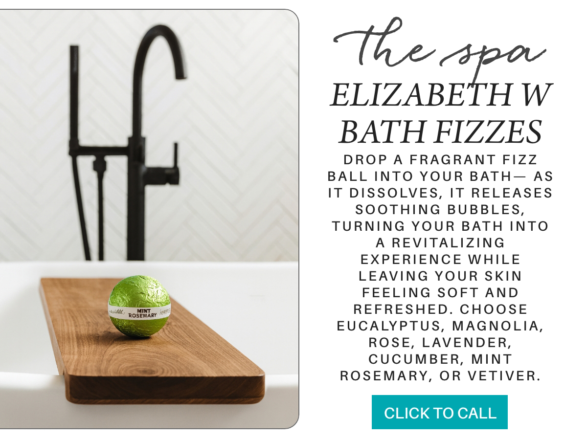 A green mint rosemary bath fizz sits on a wooden tray over a white tub with a black faucet. Text describes Elizabeth W Bath Fizzes, their soothing scents, and a button reads "Click to Call. Fearrington Village "Drop a fragrant fizz ball into your bath— As it dissolves, it releases soothing bubbles, turning your bath into a revitalizing experience while leaving your skin feeling soft and refreshed. choose eucalyptus, magnolia, rose, lavender, cucumber, mint rosemary, or vetiver."