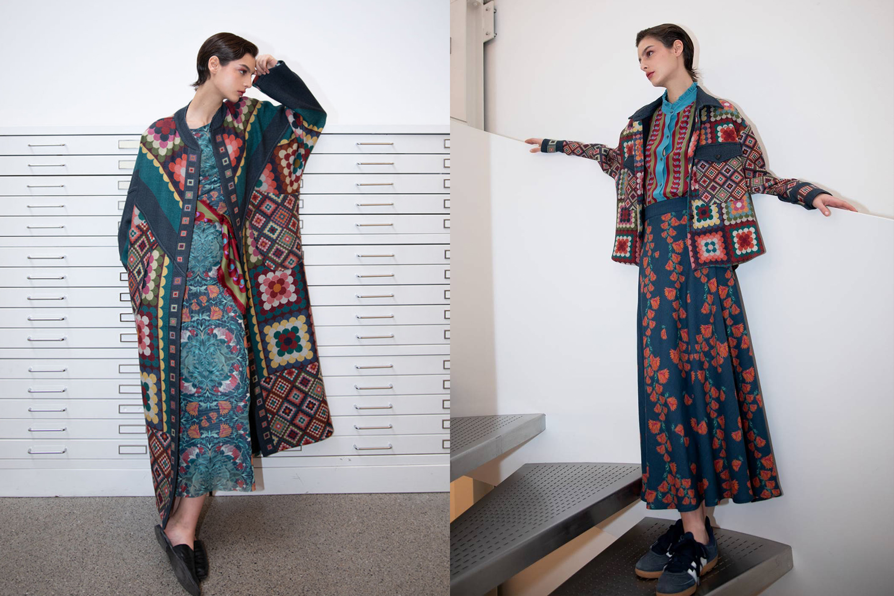 Two women stand indoors, each wearing colorful, patterned outfits with patchwork designs and floral motifs. One poses by drawers with a long coat, while the other stands on stairs in a matching skirt and jacket ensemble. Fearrington Village